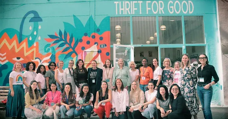 Group of people outside a THRIFT FOR GOOD shop, representing community partners in a corporate reuse initiative