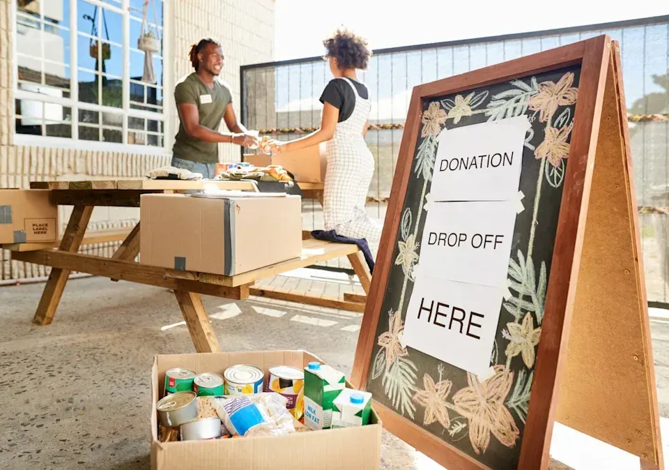 People exchanging donated items at an outdoor drop-off point, supporting a moderated free items community in the UAE
