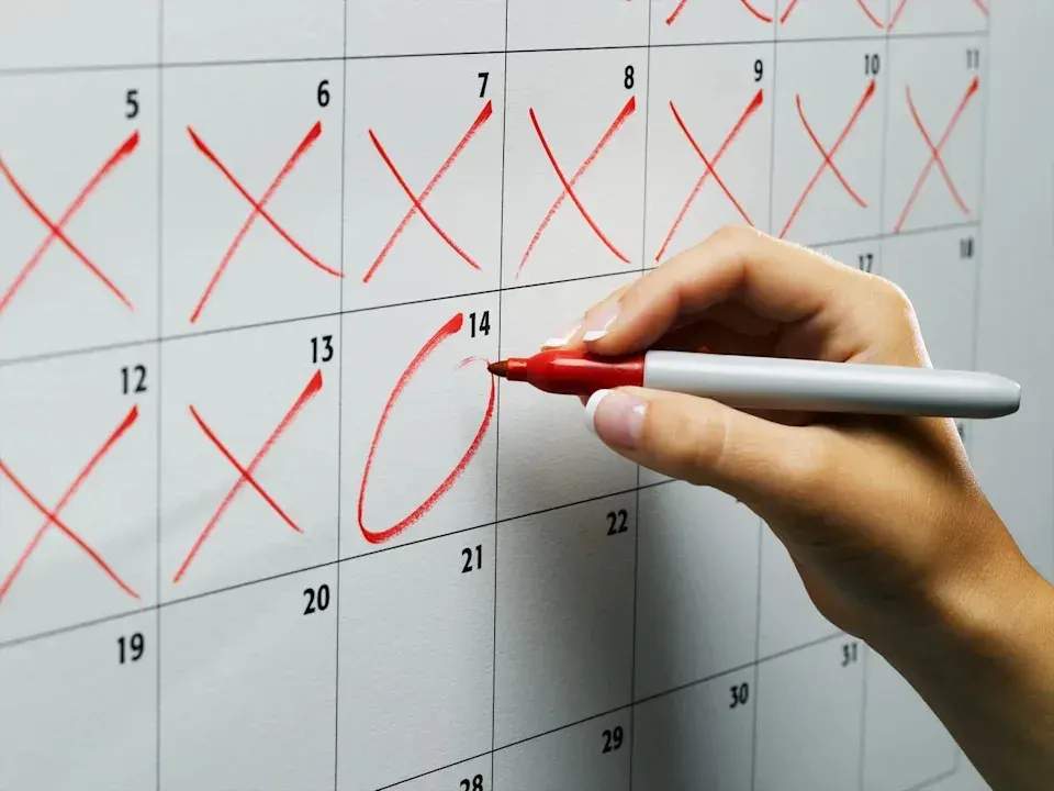 Hand marking dates on a calendar, useful for planning when UAE families pass on school uniforms, books, and supplies between terms. Hand marking dates on a calendar, useful for planning when UAE families pass on school uniforms, books, and supplies between terms.