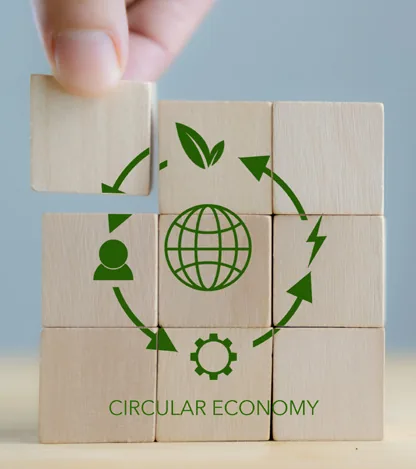 Hand arranging wooden blocks into a circular economy symbol, representing reuse and recycling for a UAE circular economy app