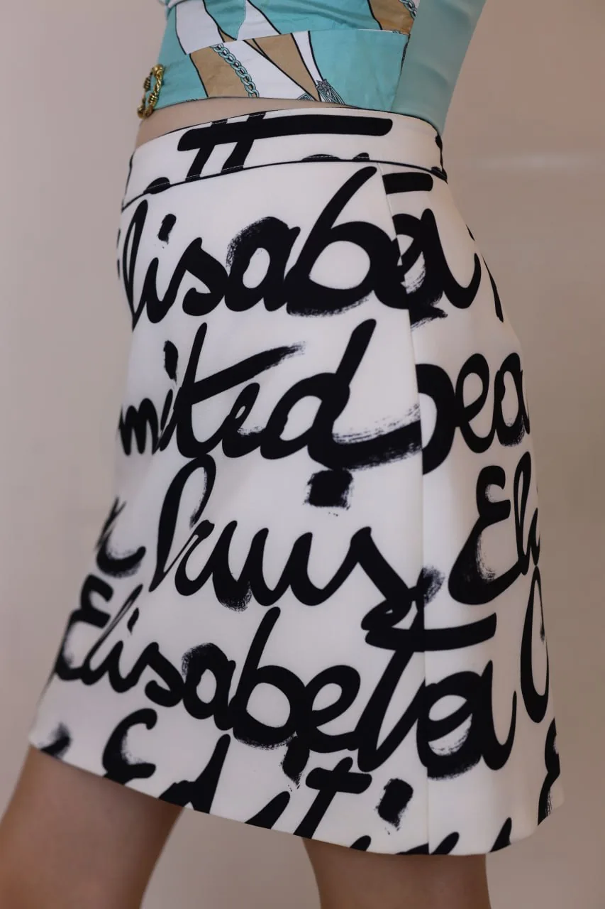Close-up of a person wearing a white skirt with black script and a teal patterned top, used for a listing and discovery hub in the UAE reuse community Close-up of a person wearing a white skirt with black script and a teal patterned top, used for a listing and discovery hub in the UAE reuse community