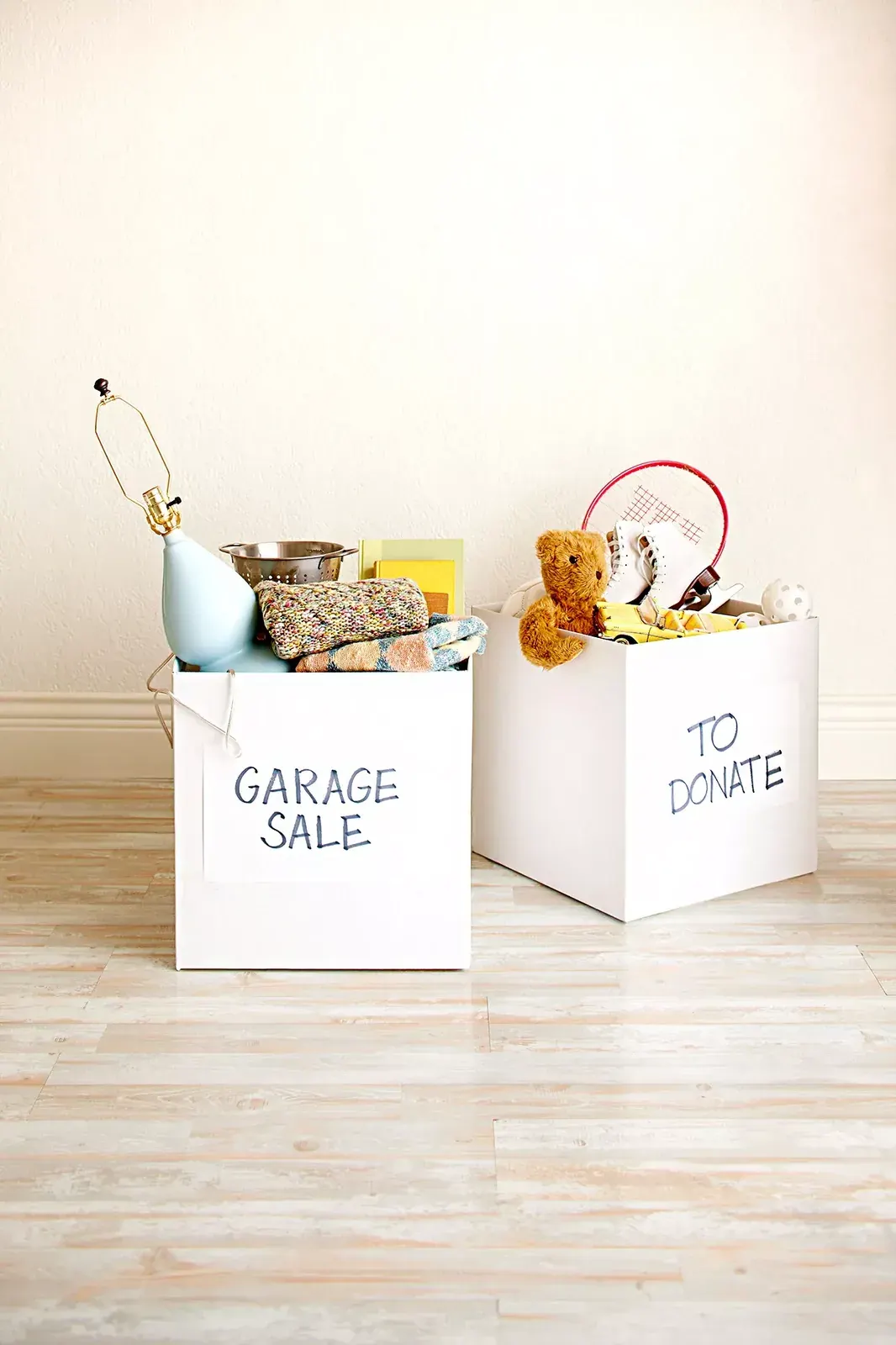 Storage boxes labeled for garage sale and donation, with reusable household items inside