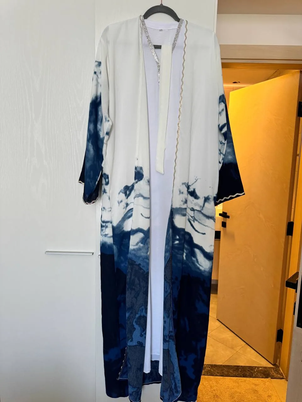 Long tie-dye robe hanging on a doorway hanger, ready to be shared peer to peer instead of thrown away Long tie-dye robe hanging on a doorway hanger, ready to be shared peer to peer instead of thrown away