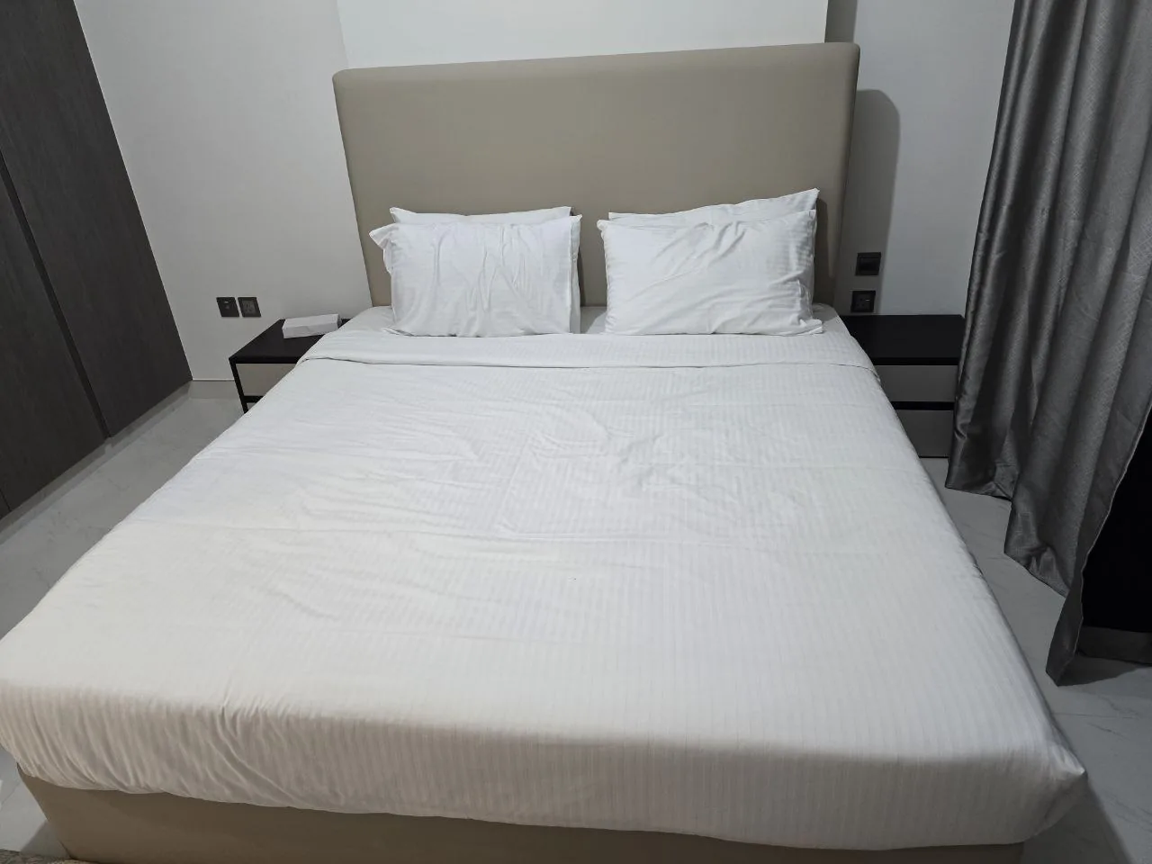 Neat bedroom with modern bed and headboard, representing second-hand home furniture in Dubai