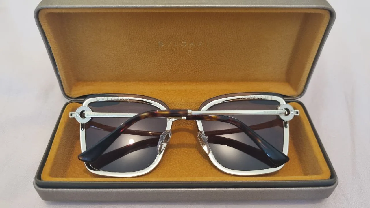 White bunk bed in a simple room with a ladder and two mattresses