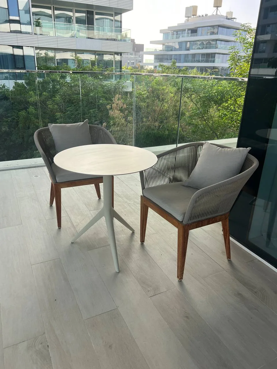 Urban balcony with two chairs and a small table, suggesting a compact outdoor space for reusing and enjoying garden items