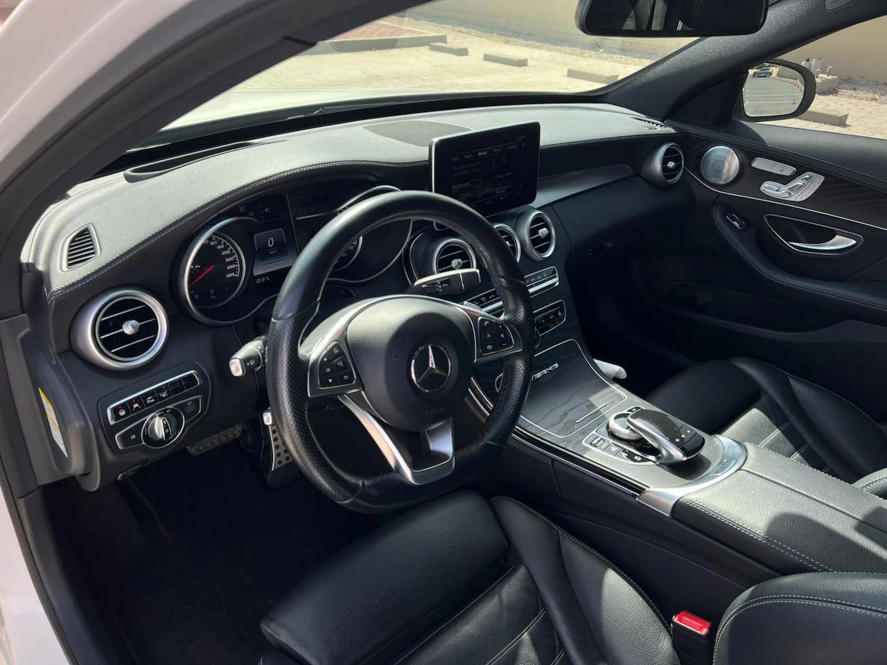 Close-up of a modern Mercedes-Benz car interior with steering wheel and dashboard controls