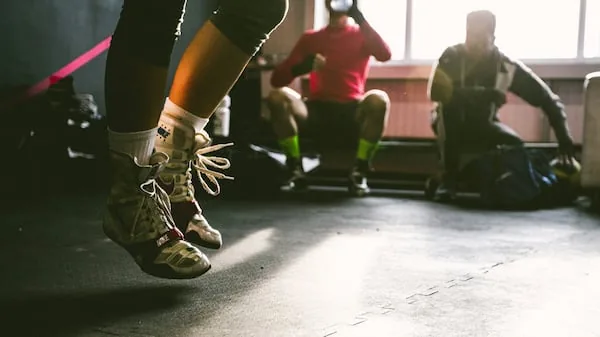 People exercising in an indoor gym, focusing on athletic footwear during a group workout session