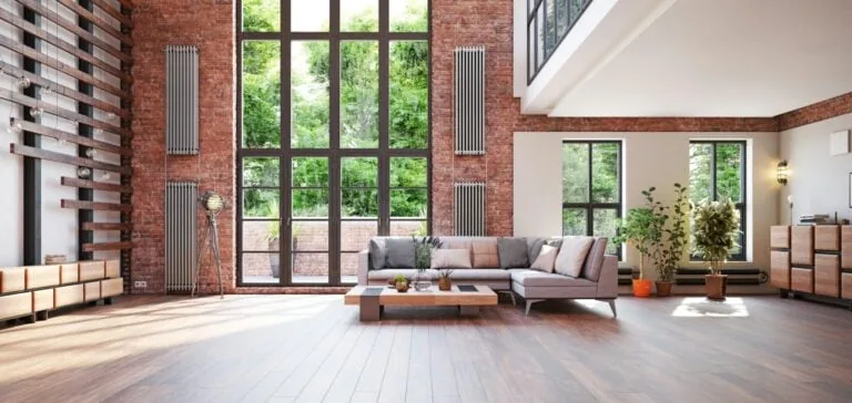 Modern open living room with brick columns and large windows in a first apartment setting