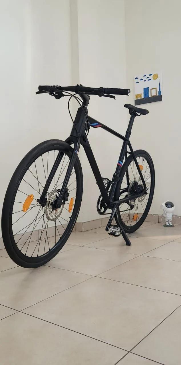 Black bicycle stored indoors against a wall in a small shared flat