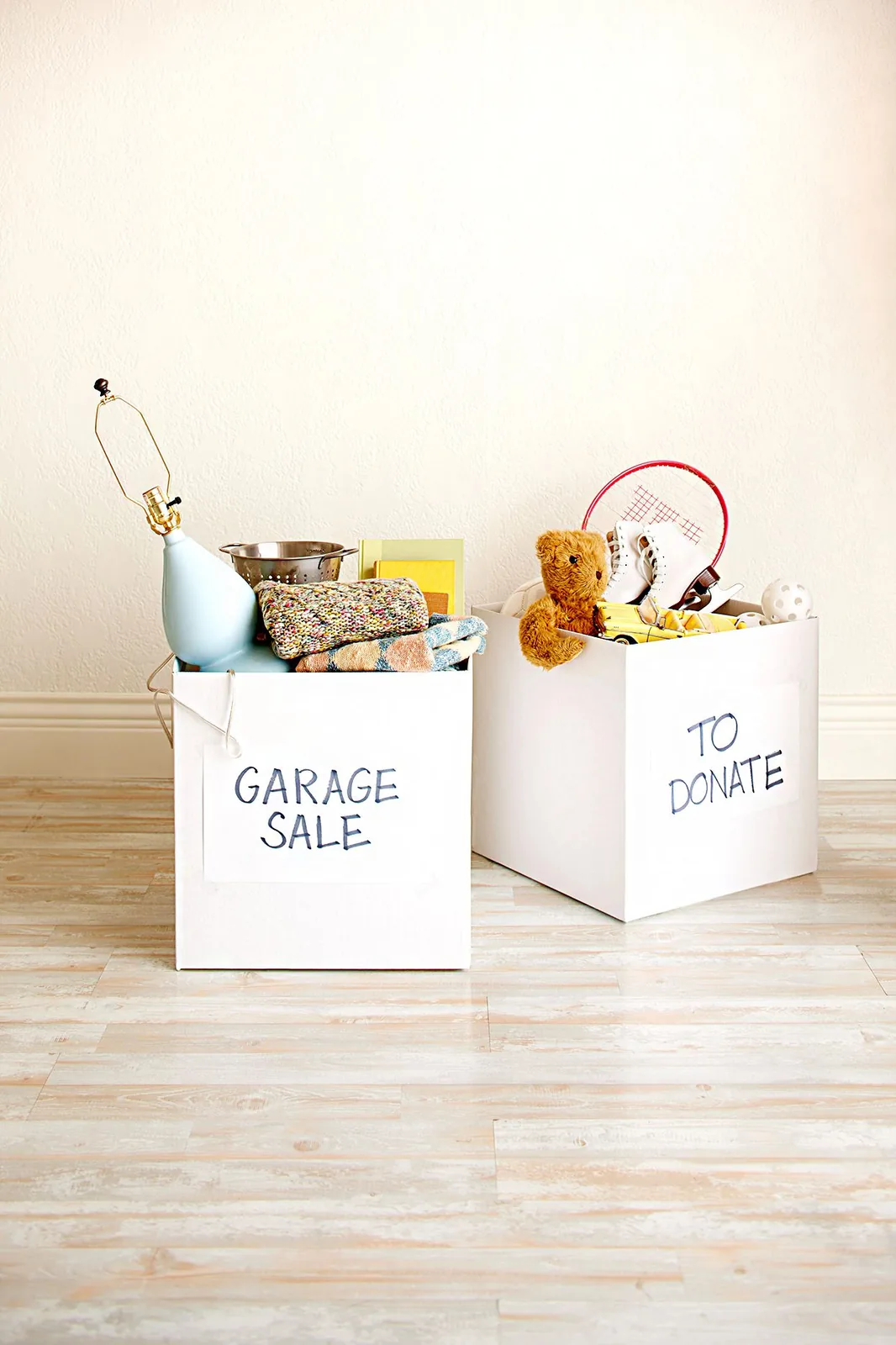 Two labeled boxes for garage sale and donation with toys and household items ready to be reused in a home setting